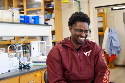 Austin Gray looks down smiling in his lab