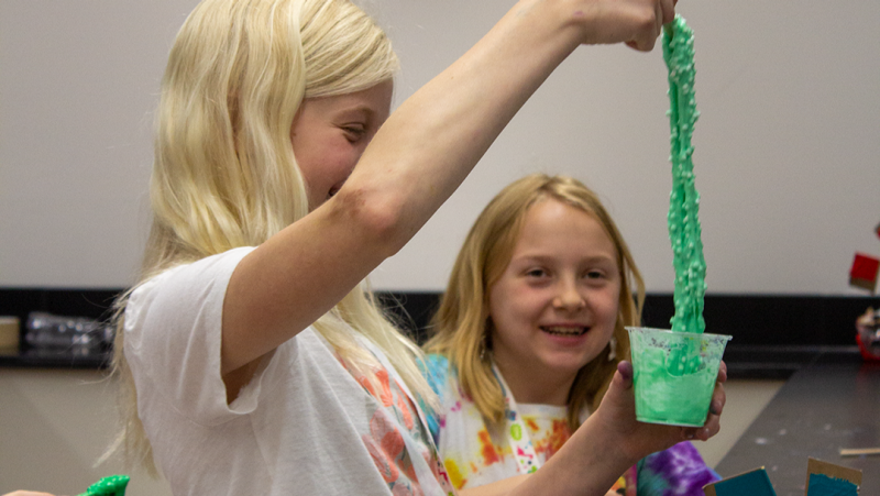 Two girls playing with slime as part of the STEM summer camp.