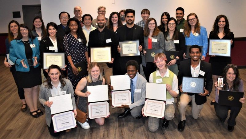 The 2023 Graduate School award winners. Several honorees could not attend the reception, and College of Natural Resources and Environment Master's Student of the Year Darby McPhail attended via the phone being held by Marcella Kelly (at bottom right). Virginia Tech photo.