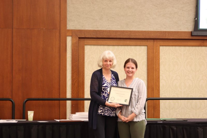 Ash VanWinkle,, master's student, receives an award from Dorothea Tholl at the 2022 PSNA conference. 